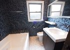 The bathroom with jacuzzi tube and glass tile walls.jpg